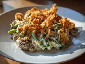 A close-up serving of creamy green bean casserole topped with crispy fried onions.