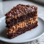 A decadent slice of german chocolate cake recipe showing rich dark layers and coconut-pecan frosting.