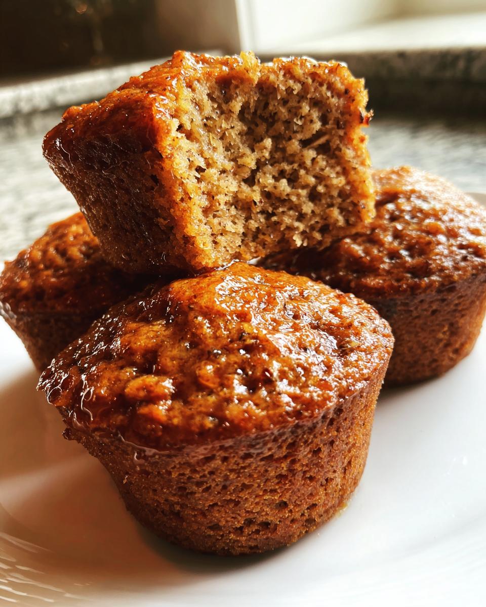Close-up of moist honey bran muffins, one cut open showing the texture.