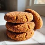 A close-up stack of soft, crackled pumpkin snickerdoodle cookies coated in cinnamon sugar.