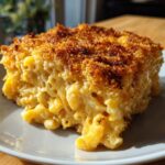 A close-up of a hearty serving of baked mac and cheese with a crispy, golden-brown topping.