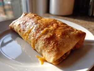 A single, golden-brown, crispy Baked Chicken Chimichangas resting on a white plate, glistening under sunlight.