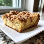 A square slice of moist french toast casserole topped with a thick layer of cinnamon streusel topping.